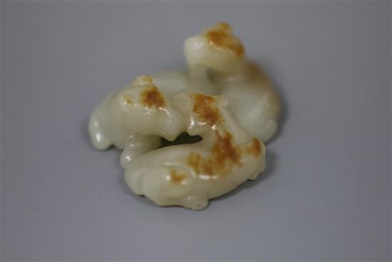 A Chinese pale celadon and russet jade group of three goats, 19th/20th century, 5cm, wood stand